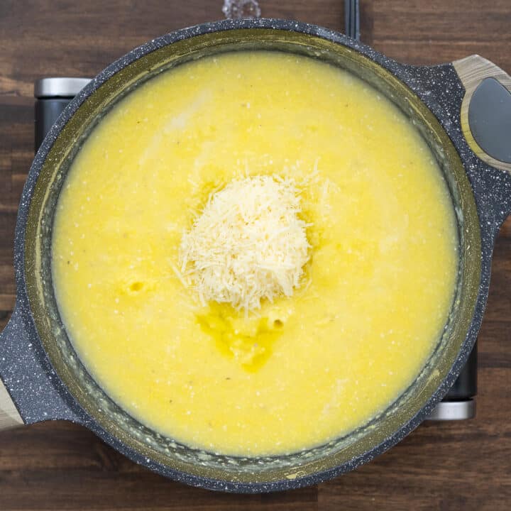 A pan with cooked polenta and Parmesan cheese.