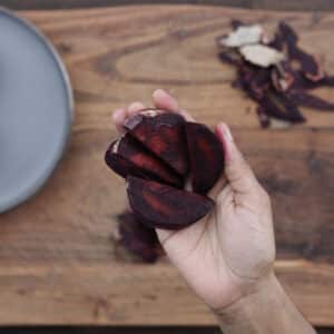 Perfectly sliced beets displayed in hands.
