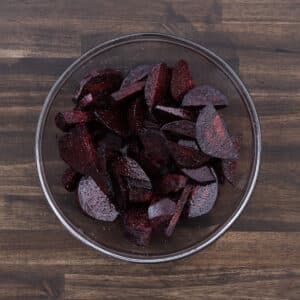 A bowl filled with seasoned beets mixed with basic seasoning.