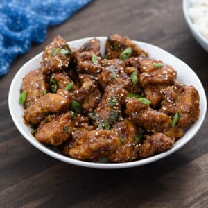 Sesame chicken served in a white bowl.