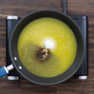 A pan showing a mixture of orange juice, white sugar, and brown sugar.