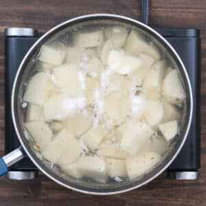 A pot with simmering potatoes in water.