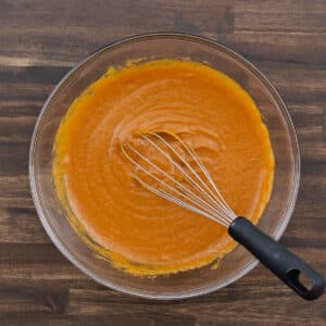 A bowl with the pumpkin puree mixture blended smoothly, showing a rich and creamy texture.