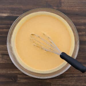A bowl filled with prepared pumpkin pie filling, smooth and ready for pouring into the crust.