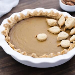 Pumpkin pie served on a white pie dish, ready to be enjoyed.