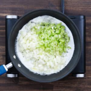 A pan with onion, celery, and garlic sautéed in the butter mixture.