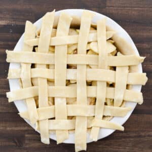 A completed lattice crust covering the apple filling, edges left unfinished.