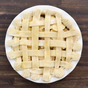 The prepared apple pie with a shiny egg-washed lattice crust and a sprinkle of coarse sugar.
