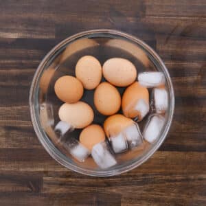 A bowl of ice-cold water with hard-boiled eggs, cooling after boiling.