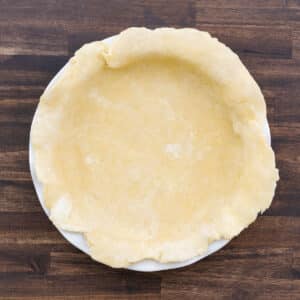 A pie dish with rolled pie dough perfectly placed inside.