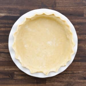 A pie dish with rolled pie crust perfectly fluted on the sides for visual appeal.