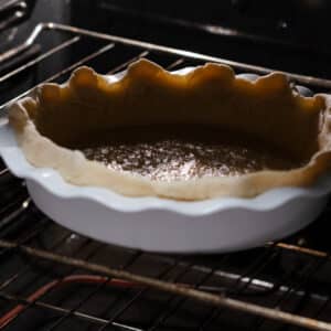 Pie crust pre-baking in the oven without parchment paper or pie weights.