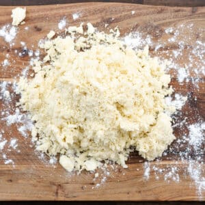A flour-dusted wooden board with pie dough mixture.