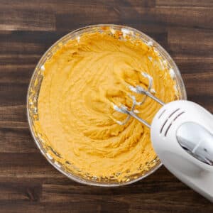 A bowl of blended pumpkin dip mixture with a creamy, smooth texture.