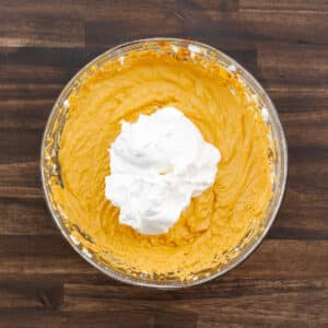 A bowl showing the pumpkin mixture with whipped topping added to it.