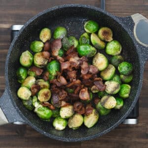 Roasted Brussels sprouts tossed with crispy bacon, seasoned with salt and black pepper.