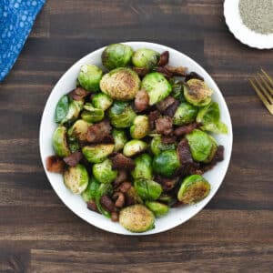 A bowl of perfectly roasted Brussels sprouts with bacon, ready to be enjoyed.