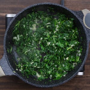 A pan with sautéed spinach, soft and wilted.