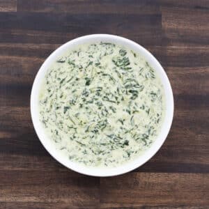 Creamed spinach served in a white bowl, ready to enjoy.