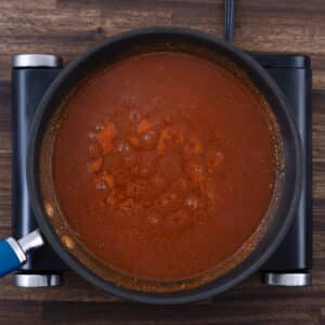 A pan with taco sauce ingredients simmering on the stove.
