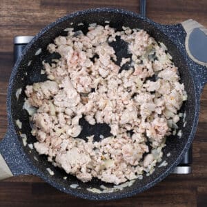 A pan with cooked ground meat, fully cooked and ready for seasoning.