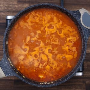 A pan with taco soup ingredients simmering together, bubbles forming on the surface.