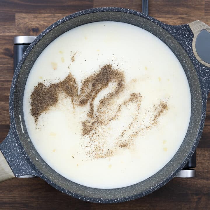 A pan with a milk mixture seasoned with black pepper, salt, and Dijon mustard.