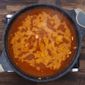 A pan with vegetables and beans simmering in a flavorful broth.
