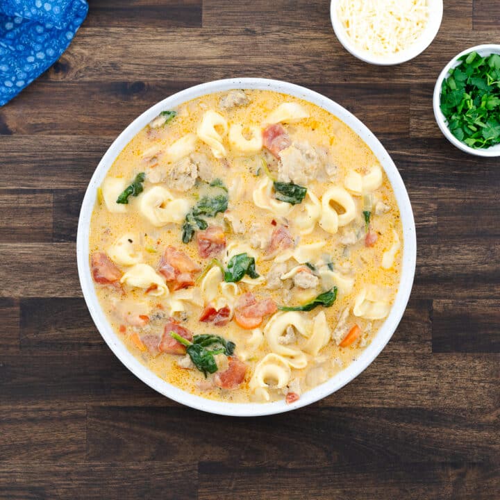 Tortellini soup served in a white bowl, ready to enjoy.