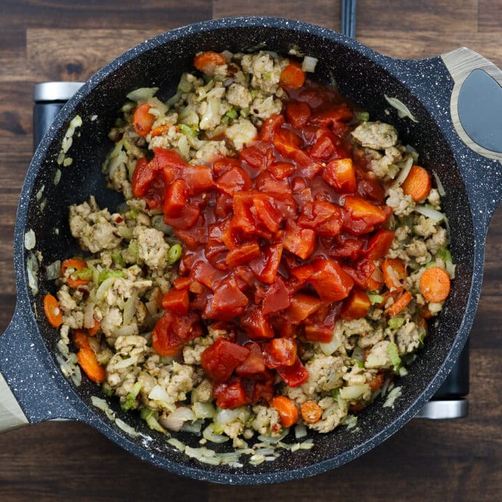 Pan with meat, sautéed veggies, roux, and diced tomatoes.