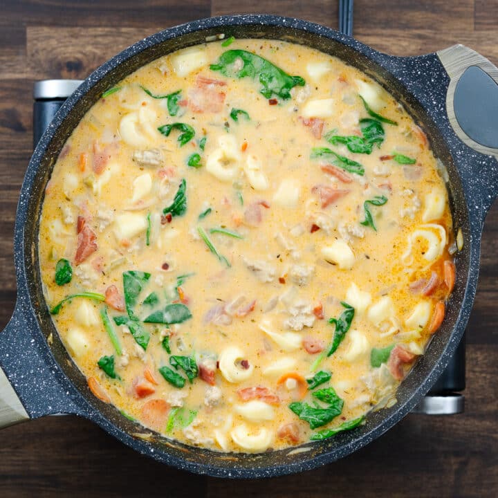 Pan with creamy tortellini soup, ready to serve.