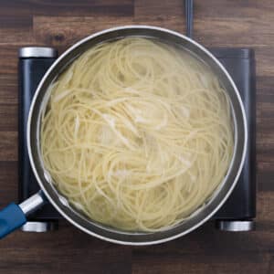 A pan with spaghetti pasta in hot boiling water, cooking to al dente.