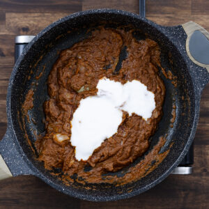 Coconut milk added to the pan with curry paste.