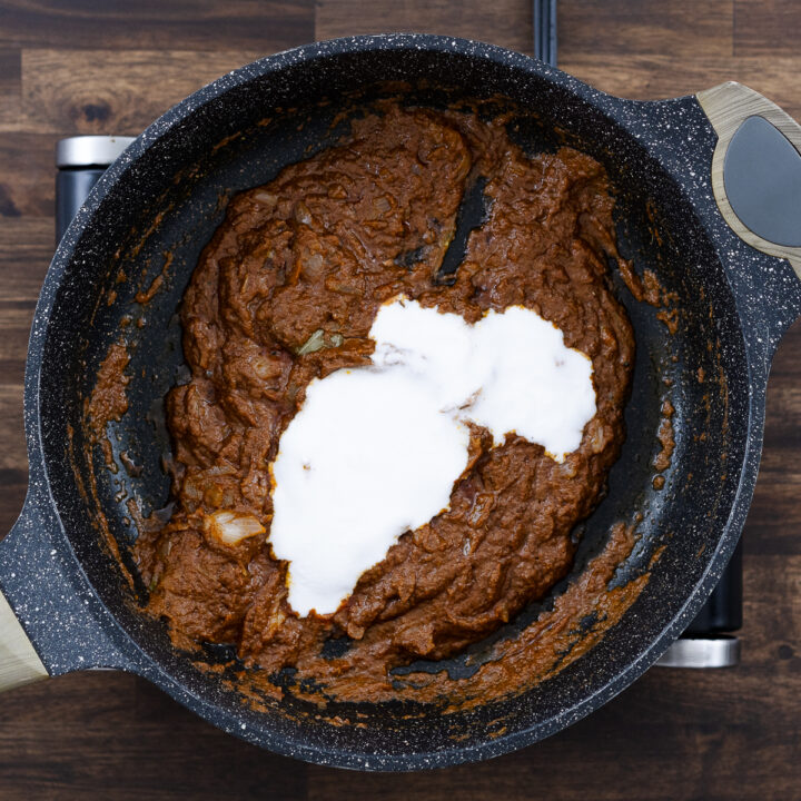 Coconut milk added to the pan with curry paste.