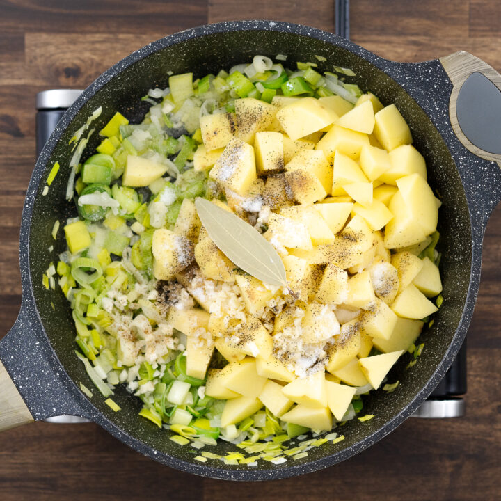 A pan filled with sautéed leeks, diced potatoes, and aromatic herbs and seasonings.
