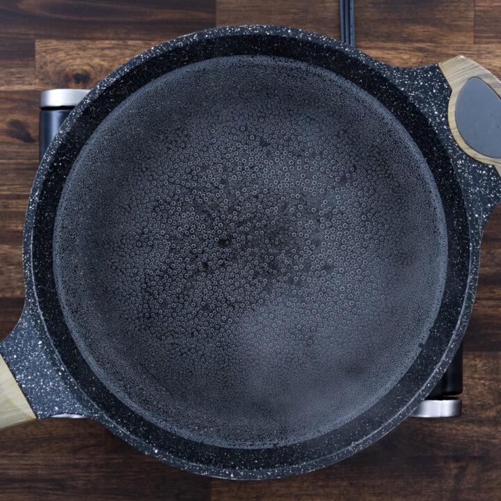 A pot starting to lightly boil with water.