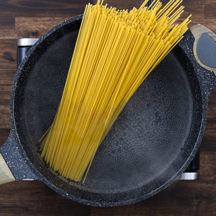 A pot with spaghetti pasta in boiling water.