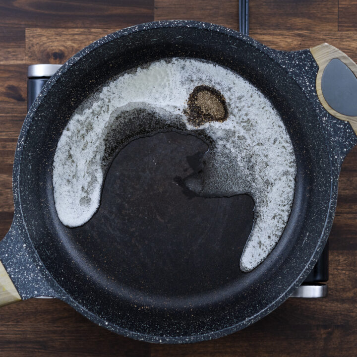 A pan with melted butter and freshly cracked black pepper.