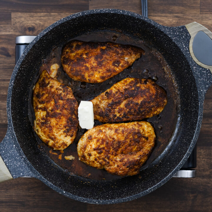 Butter melting in the pan with the seared chicken breasts for extra flavor.